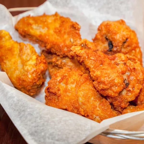 Antigoni's Pizza's crispy, golden-brown fried chicken wings served in a basket lined with white paper.
